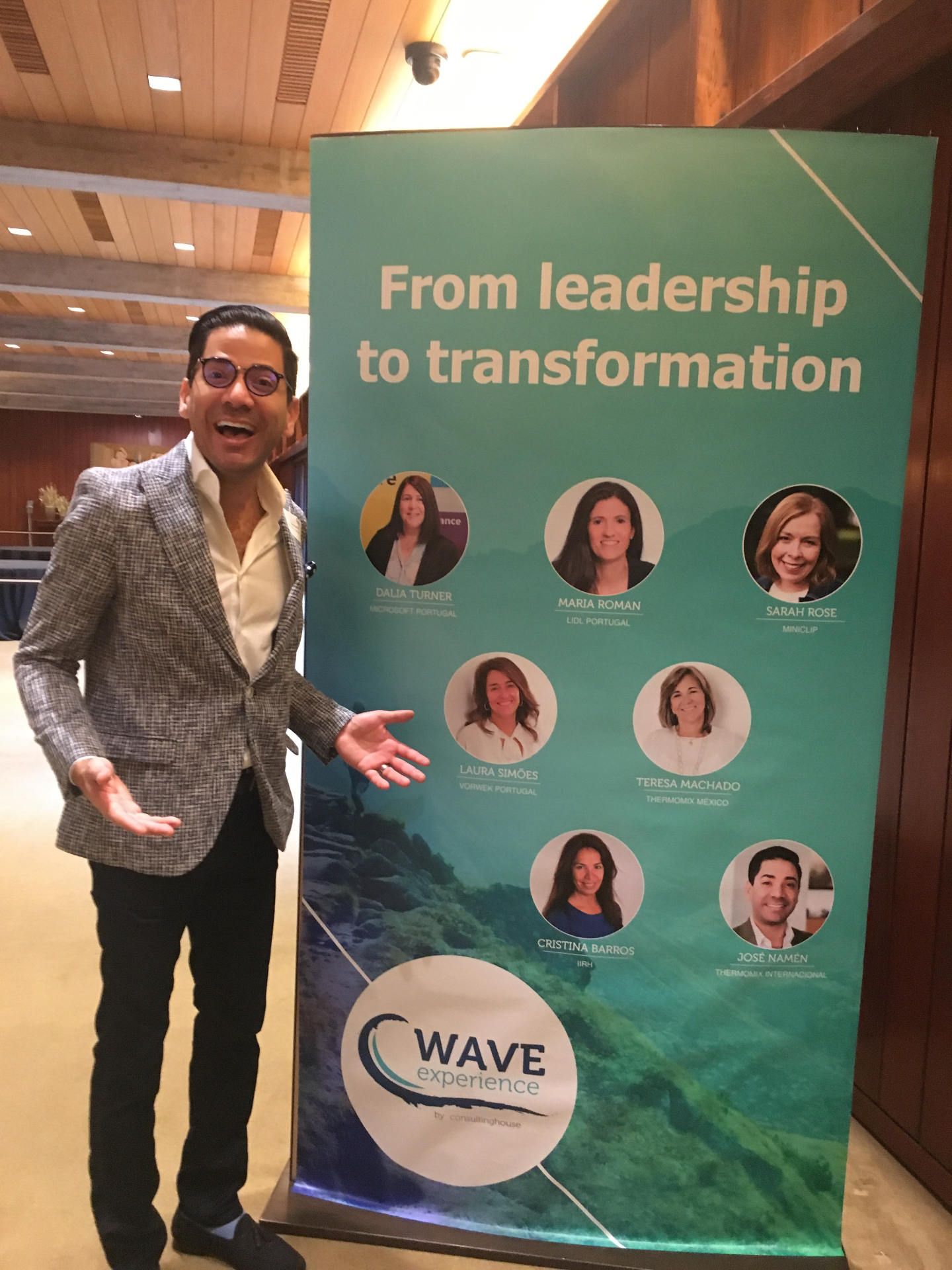José Namén next to the Wave Experience speaker banner at the leadership transformation event in Lisbon.